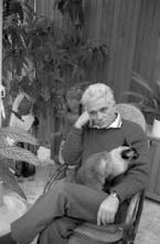 Jacques Derrida sitting in a chair with a cat on his lap