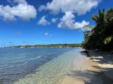 Beach view of an island in the Caribbean with sailboats in the distance