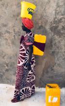 Woman carrying water on her head, back, and by a chain