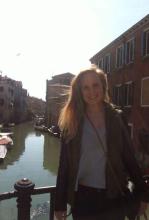 Emma Smith standing over a sunny canal in Venice 